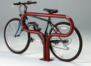 A red, uniquely shaped metal bicycle rack holding a mountain bike